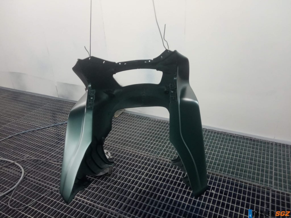 Carenado de motocicleta en proceso de pintado desde atrás