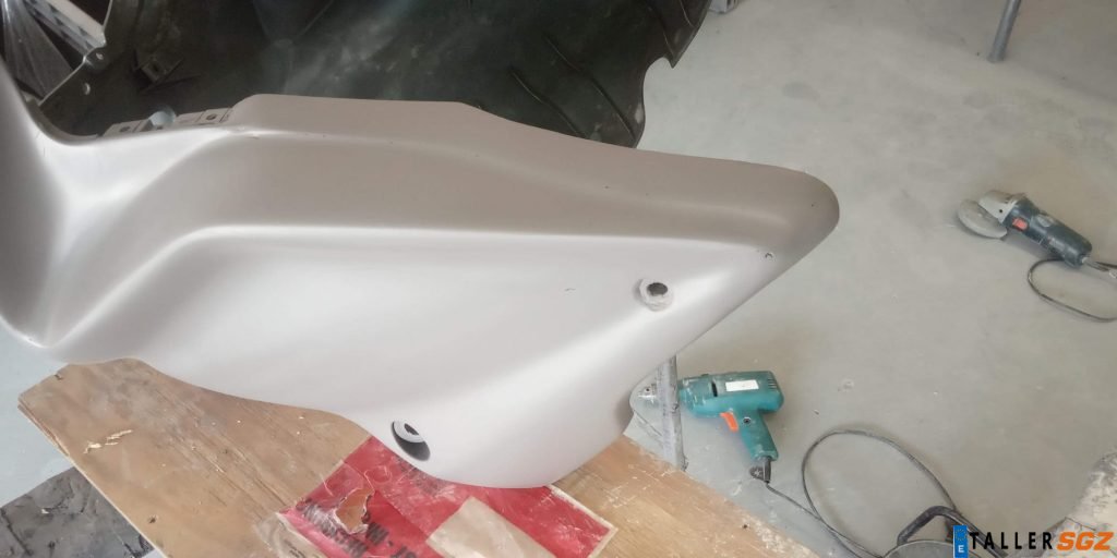 Carenado de motocicleta en proceso de reparación imprimación